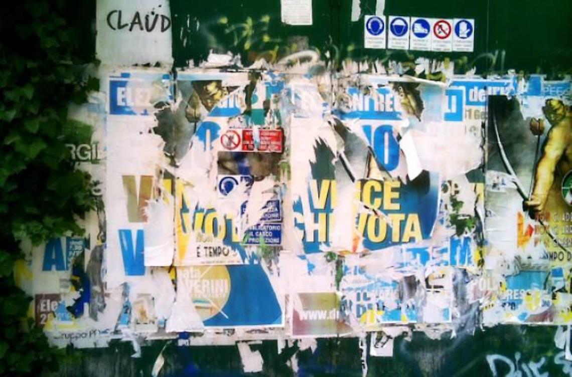 Manifesti strappati in uno spazio pubblicitario