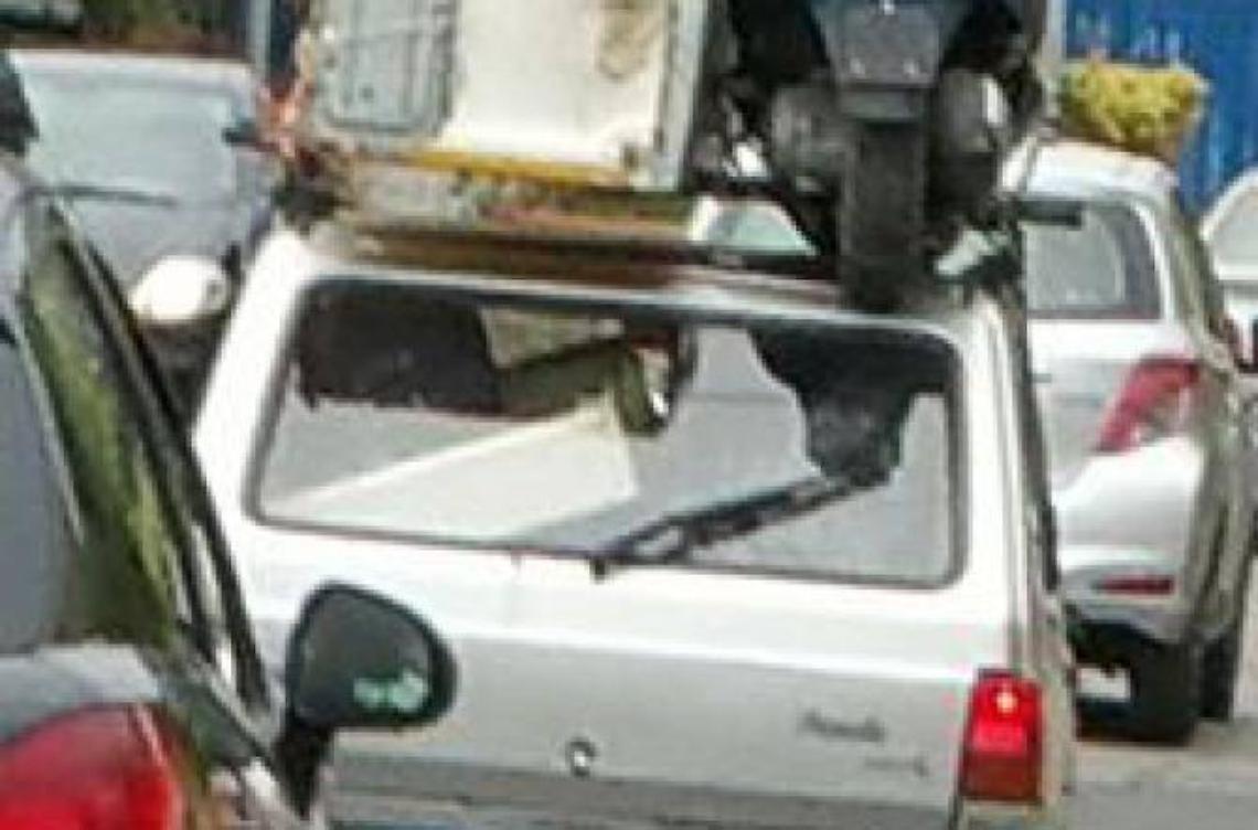 Con il motorino sul...tetto dell'auto: la foto fa il giro del web