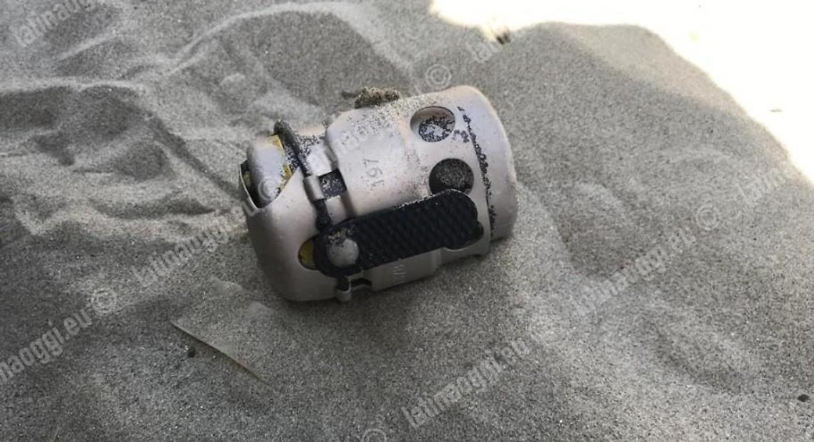 Bomba a mano trascinata sulla spiaggia dalla corrente