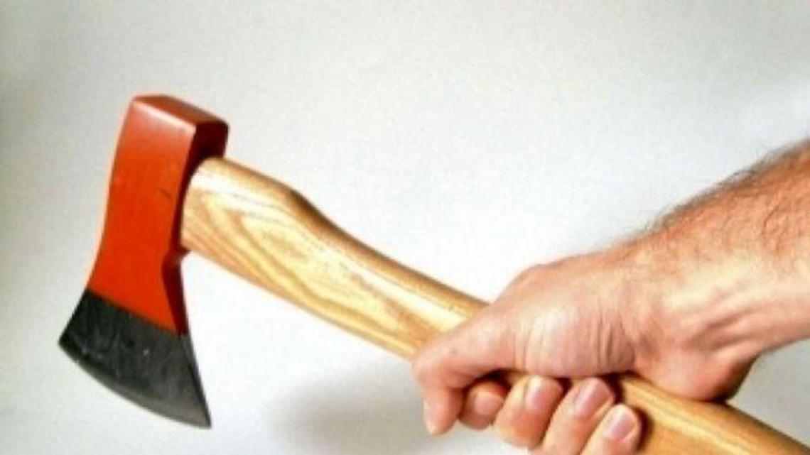 Con una maschera horror e un'ascia tenta di uccidere un uomo