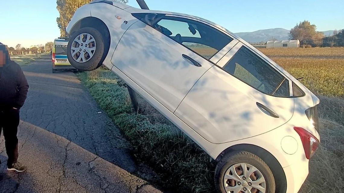 Sbanda a causa del ghiaccio, l'auto finisce sul tirante di un palo