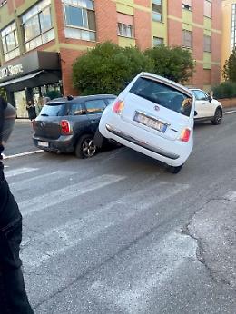 Urta una vettura in sosta, l'auto si blocca di traverso con la ruota sollevata