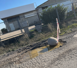Aprilia, crateri in via Baracca: cittadini spostano i blocchi di cemento per segnalare il pericolo