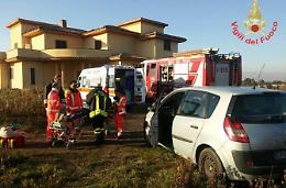 Spinge l'auto in panne ma resta incastrata sotto le ruote