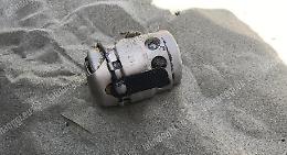 Bomba a mano trascinata sulla spiaggia dalla corrente