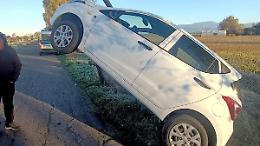 Sbanda a causa del ghiaccio, l'auto finisce sul tirante di un palo