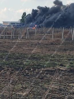 Incendio nella zona di Carano, nube densa di fumo e fiamme che lambiscono l'impianto idrico