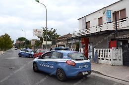 Banditi con maschere da Halloween per la rapina al tabacchi: uno punta la pistola contro un cliente