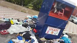 Lo scempio del cassonetto per gli abiti usati svuotato dai mendicanti
