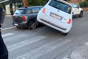 Urta una vettura in sosta, l'auto si blocca di traverso con la ruota sollevata